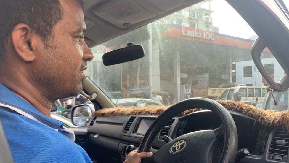 Pratheem, a 43-year-old minibus driver, is pictured waiting to fill his vehicle with petrol