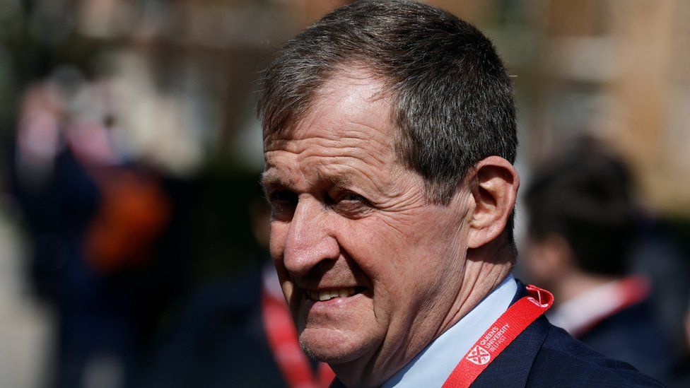 Alastair Campbell pictured from the side with the sun in his face