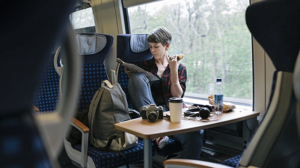 Mature woman eating her lunch while traveling on a train