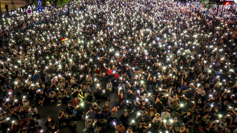 Pro-democracy protesters hold up their mobile phones during rally against the state of emergency at Ratchaprasong shopping district in Bangkok, Thailand, 15 October 2020.