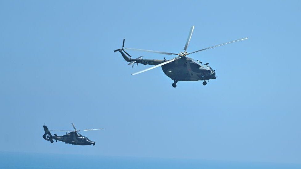 Chinese military helicopters fly past Pingtan island, one of mainland China's closest point from Taiwan, in Fujian province on August 4, 2022, ahead of massive military drills off Taiwan following US House Speaker Nancy Pelosi's visit to the self-ruled island.