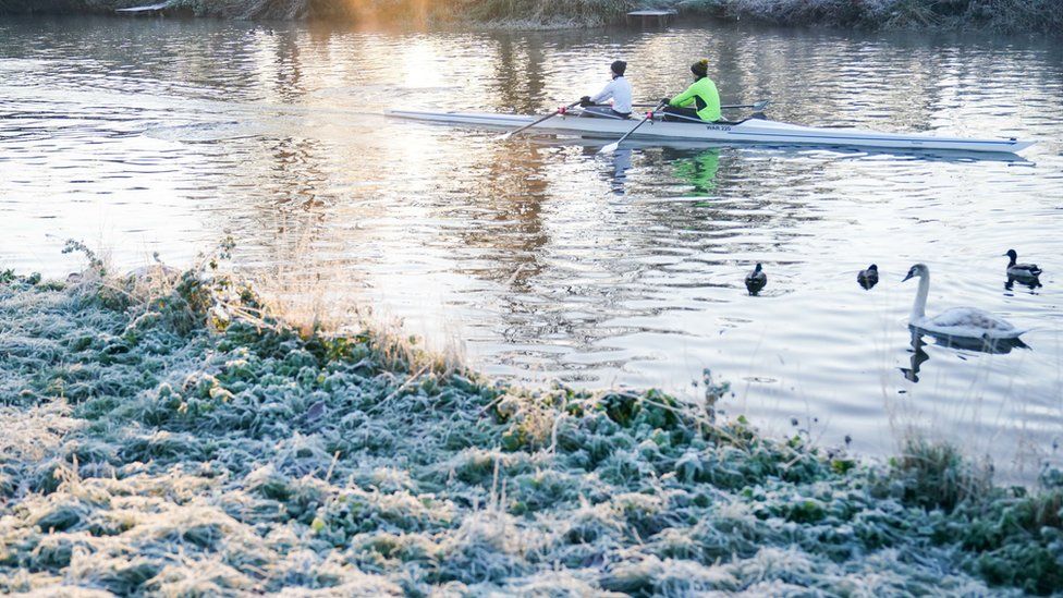 Rowers on the river Avon during a cold sunrise in Warwick.
