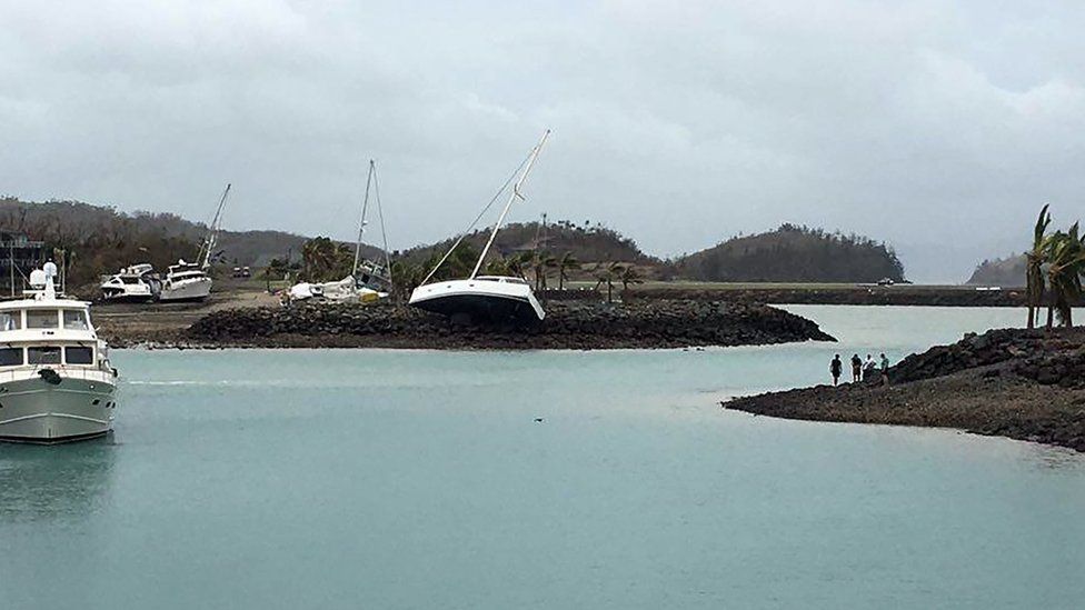 A boat (C) ran aground on Hamilton Island after strong Cyclone Debbie hit the Whitsundays Islands in Queensland on March 29, 2017
