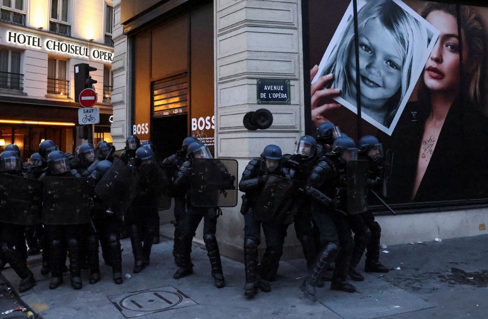 French CRS riot police stand in position amid clashes with protesters during a demonstration as part of the ninth day of nationwide strikes and protests against French government's pension reform, in Paris, France, March 23, 2023.