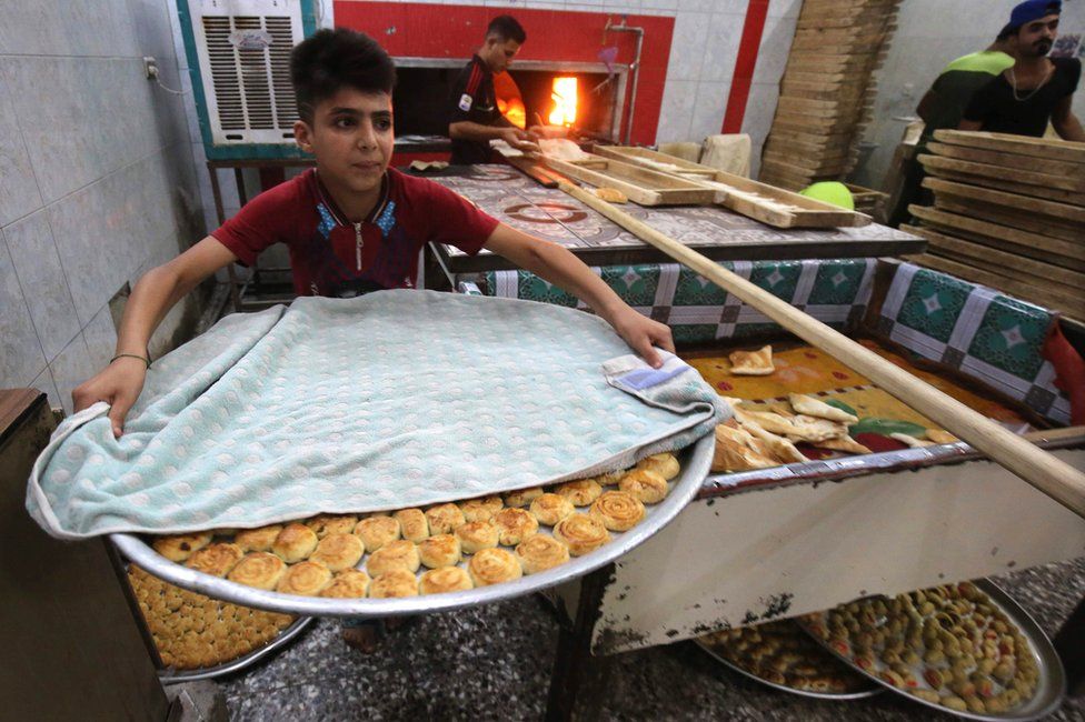 Iraqis prepare pastries known as Kliga ahead of the Eid al-Fitr Muslim festival marking the end of Ramadan, on June 14, 2018 at a pastry shop in Baghdad