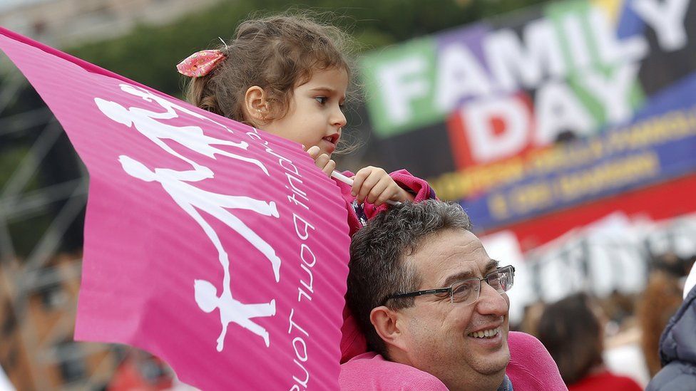 A man and girl attend a rally against same-sex unions in Italy