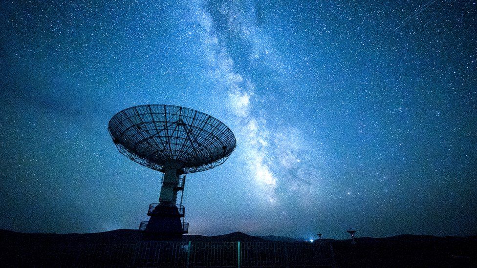 A radio telescope against a night sky