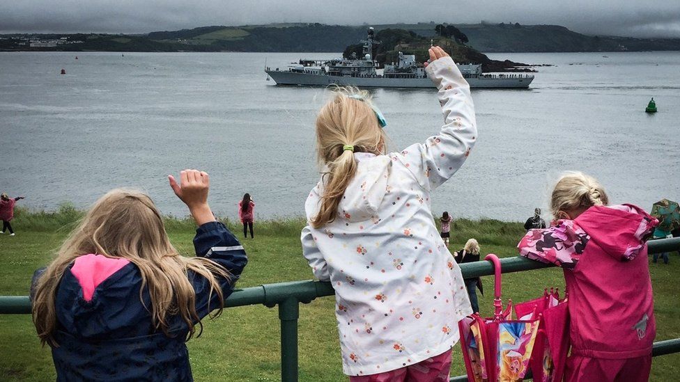 Children waving goodbye to their dad's ship