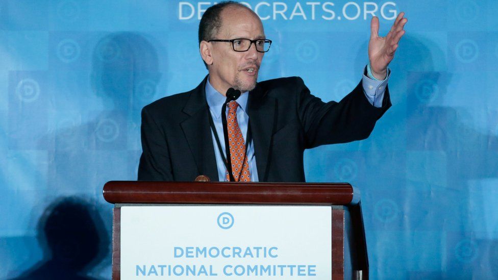 Tom Perez speaks to Democratic party delegates at a rostrum, his left hand raised in the air