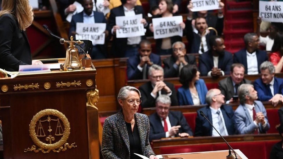 Members of Parliament of left-wing coalition NUPES (New People's Ecologic and Social Union) hold placards during the speech of France's Prime Minister Elisabeth Borne (C), as she confirms to force through pension law without parliament vote during a session on the government's pension reform at the lower house National Assembly, in Paris on March 16, 2023