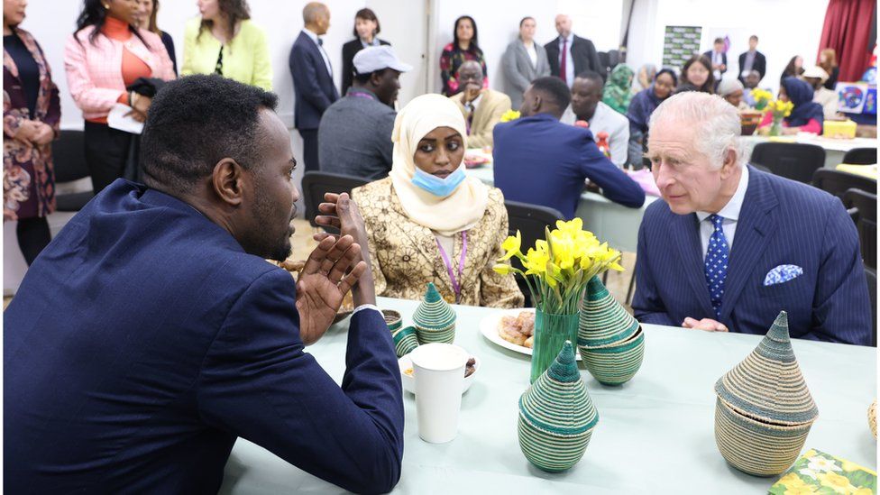 The King listens to a man at the event