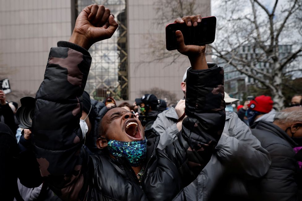 A person raises their arms after the verdict in the trial of former Minneapolis police officer Derek Chauvin, in front of Hennepin County Government Center, in Minneapolis, Minnesota