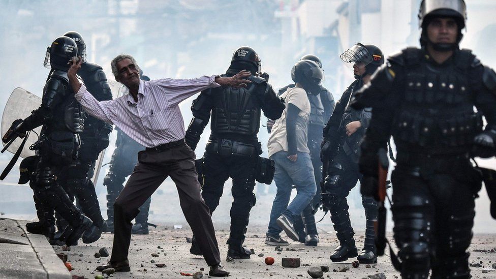 A demonstrator throws stones during a protest against a campaign rally by Timochenko in Yumbo, Colombia, on February 7, 2018