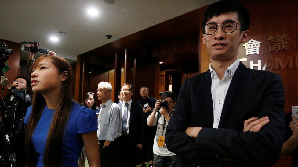 Activists Baggio Leung (R) and Yau Wai-ching (L) stand outside the chamber after pro-Beijing lawmakers staged a walk-out to stall their swearing-in at the Legislative Council in Hong Kong