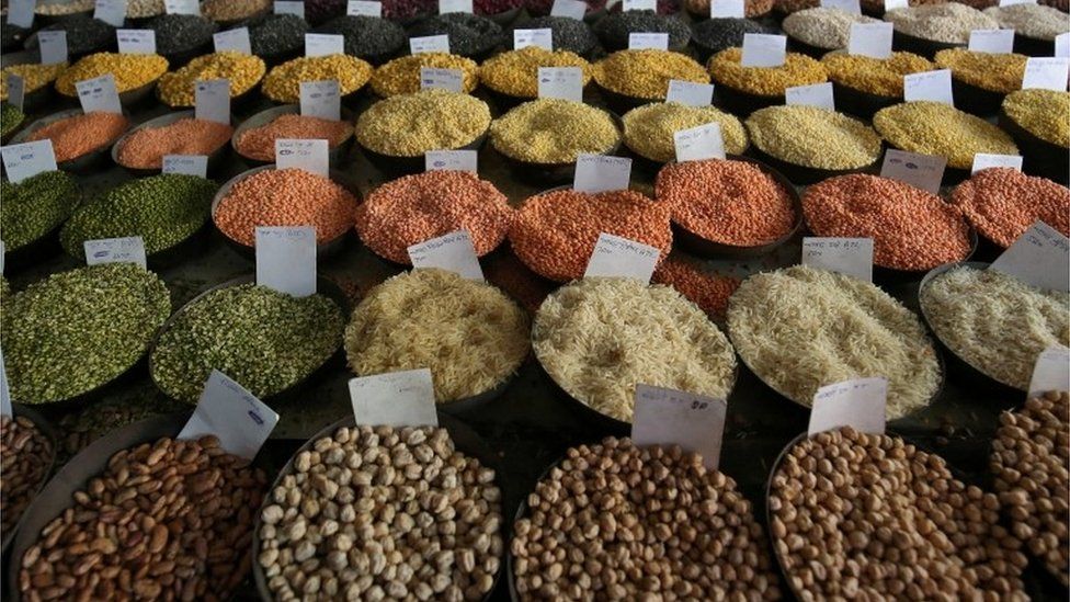 Price tags are seen on the samples of rice and lentils that are kept on display for sale at a wholesale market in the old quarters of Delhi, India