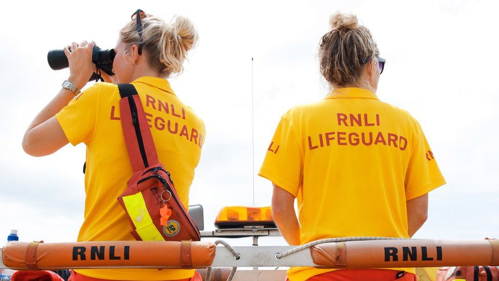 Two lifeguard sat atop rescue vehicle