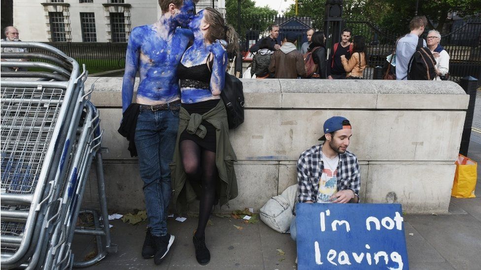 A young couple painted as EU flags, protest outside Downing Street against the UK's decision to leave the EU