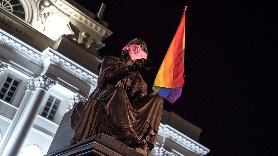 Statue of Copernicus in Warsaw with LGBT flag and pink face mask