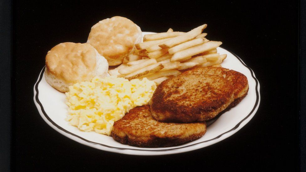 A meal featuring french fries, scones, scrambled egg and toast