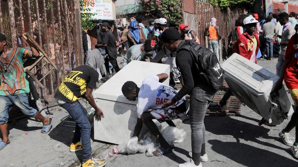 People steal a fridge from a hotel during a protest demanding the resignation of Haiti's Prime Minister Ariel Henry after weeks of shortages, in Port-au-Prince, Haiti October 10, 2022.