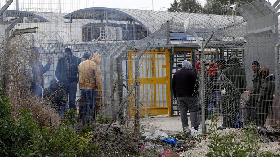 Palestinian workers wait to cross into Israeli settlement area at the Mitar checkpoint, south of the West Bank city of Hebron, 19 January 2016