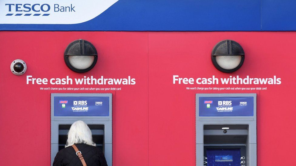 Woman withdrawing cash at Tesco Bank ATM