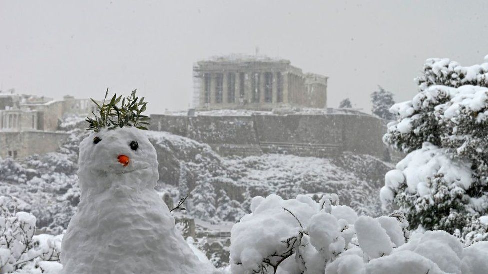 Снеговик изображен с храмом Парфенон на вершине холма Афинский Акрополь