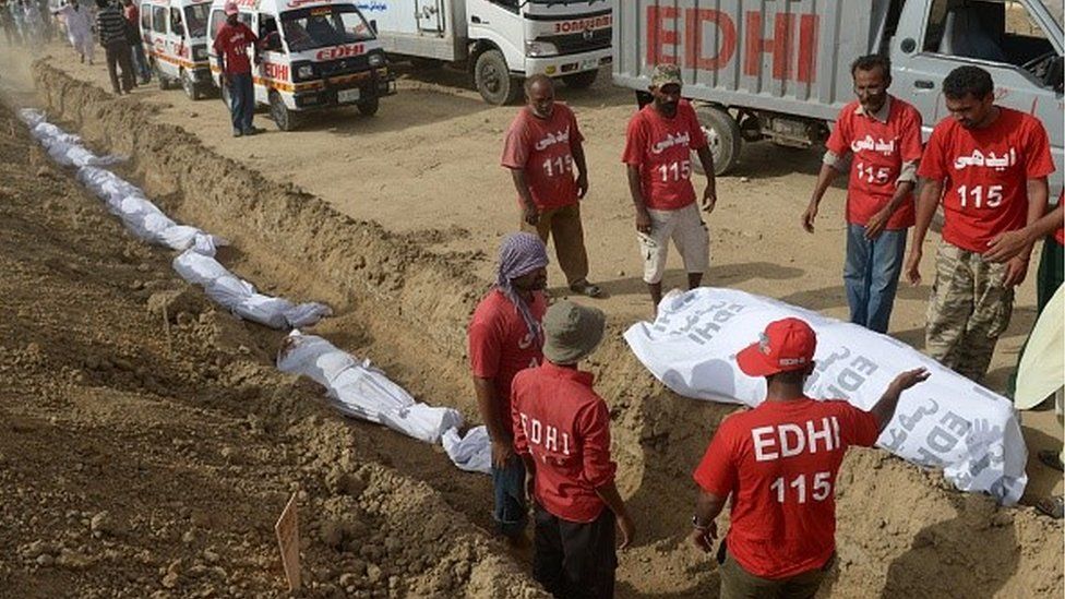 Pakistani Edhi charity volunteers bury the bodies of unclaimed heatwave victims at a graveyard in Karachi on June 26, 2015.