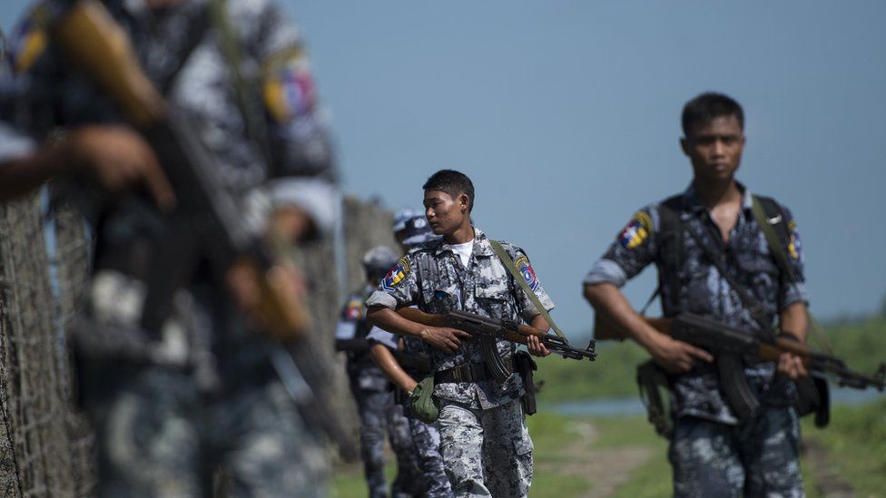 An armed Myanmar border police patrol along a fence by the river dividing Myanmar and Bangladesh border located in Maungdaw, Rakhine State on October 15, 2016
