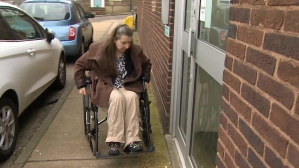 Ali Wilkin in a wheelchair outside the benefits office in Colchester.