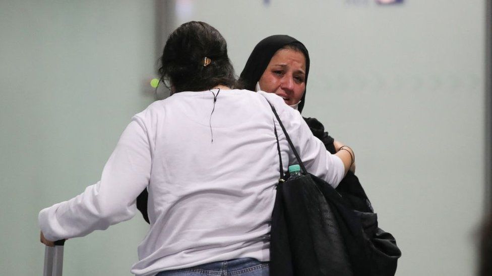 A woman weeps as she arrives among the first German and Afghan evacuees from Kabul, at Frankfurt International Airport