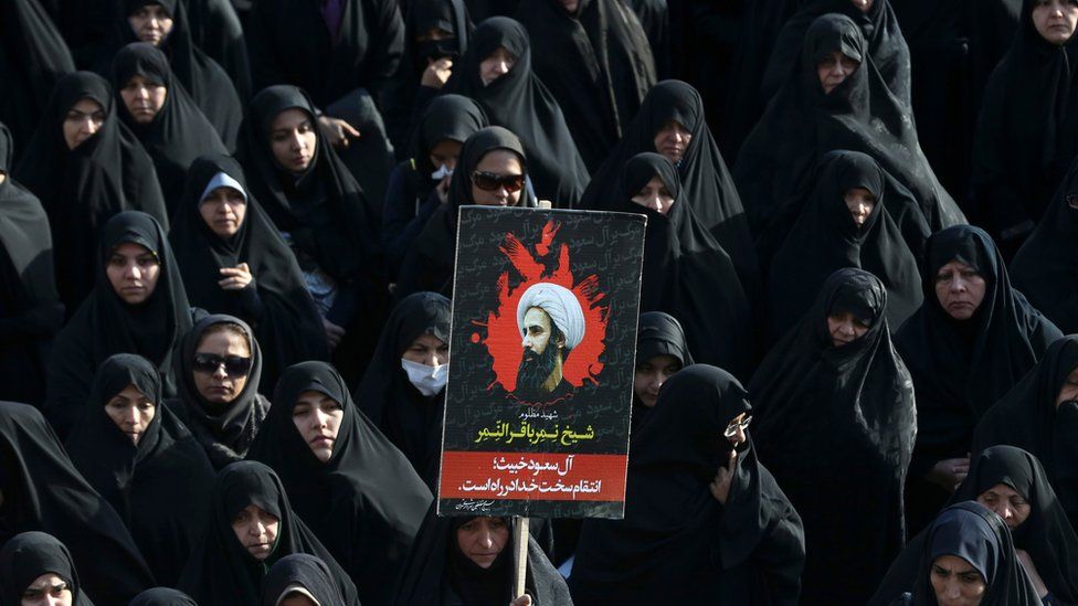 An Iranian woman holds up a poster showing Sheikh Nimr al-Nimr, a prominent opposition Saudi Shiite cleric who was executed last week by Saudi Arabia, in Tehran, Iran, Monday, Jan. 4, 2016.