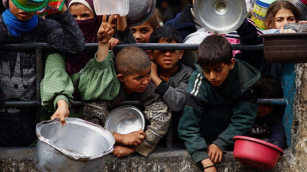 Children waiting to collect food aid in Gaza