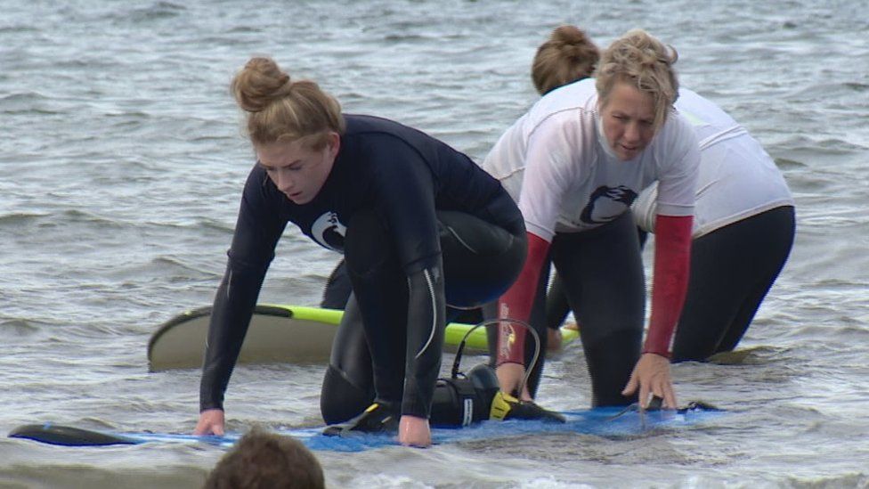 Layla Cuthill with instructor doing surf therapy