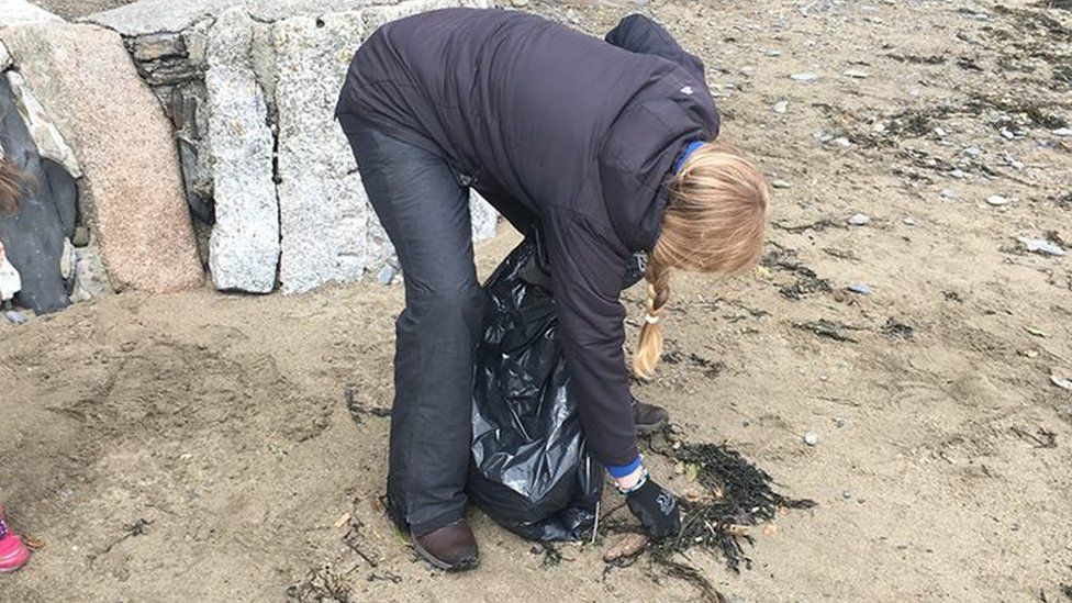 Kirstie Edwards picking up beach plastic
