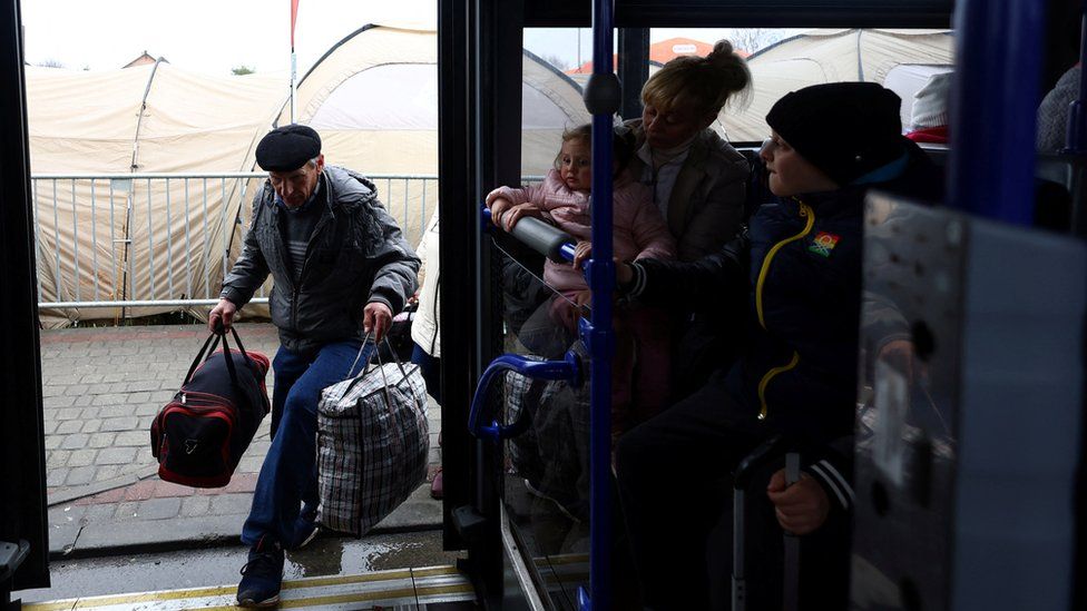 A Ukrainian refugee boards a bus, bound for Przemysl after crossing the Ukraine-Poland border
