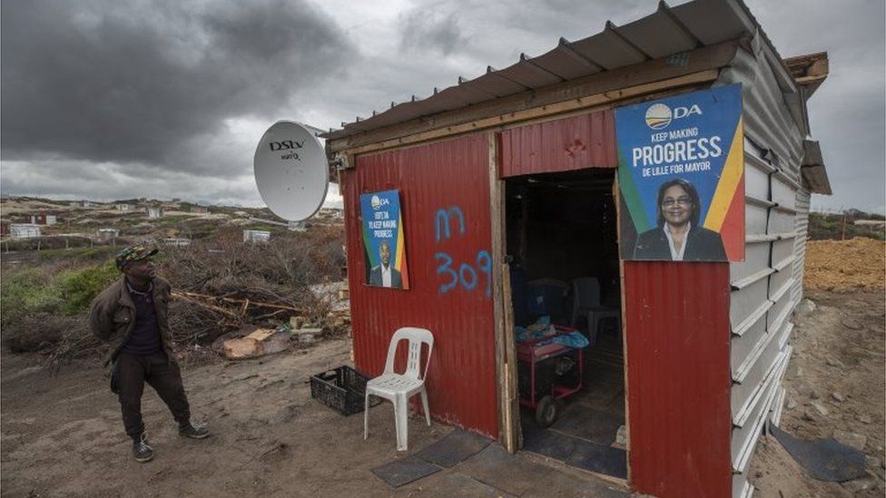 A man stands outside an illegally erected shack on unstable sand dunes in Monwabisi, Cape Town, South Africa, 18 September 2018. The area has seen thousands of illegal shacks being erected over the past months.