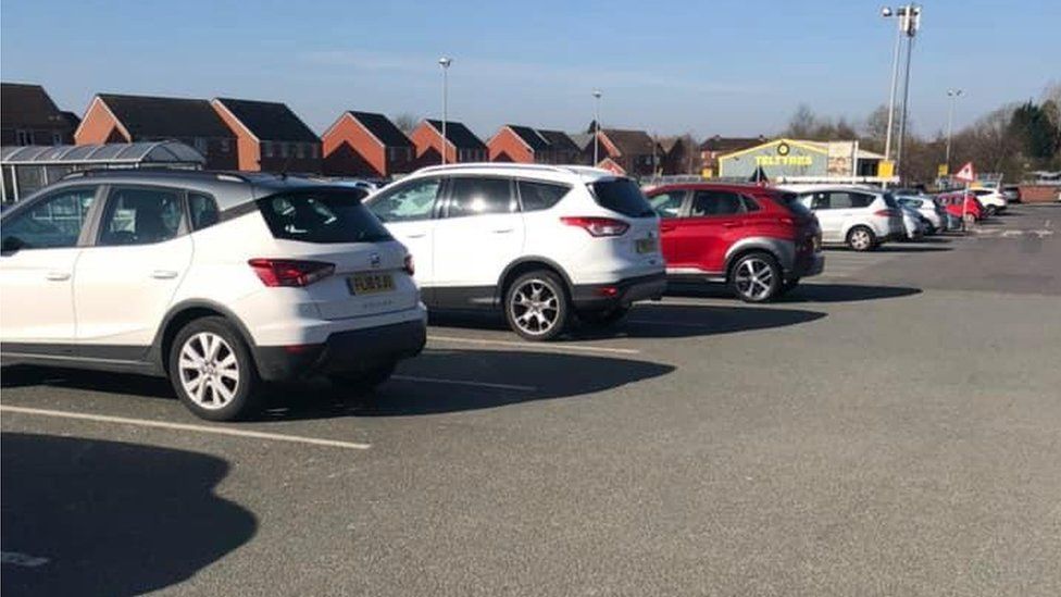 Cars spaced out at a supermarket