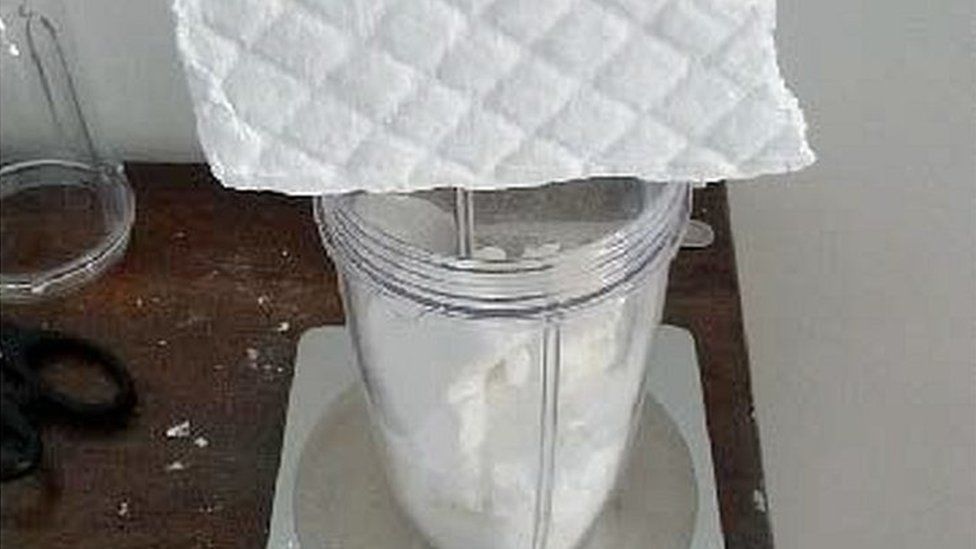cocaine block weighed in a jar on scales