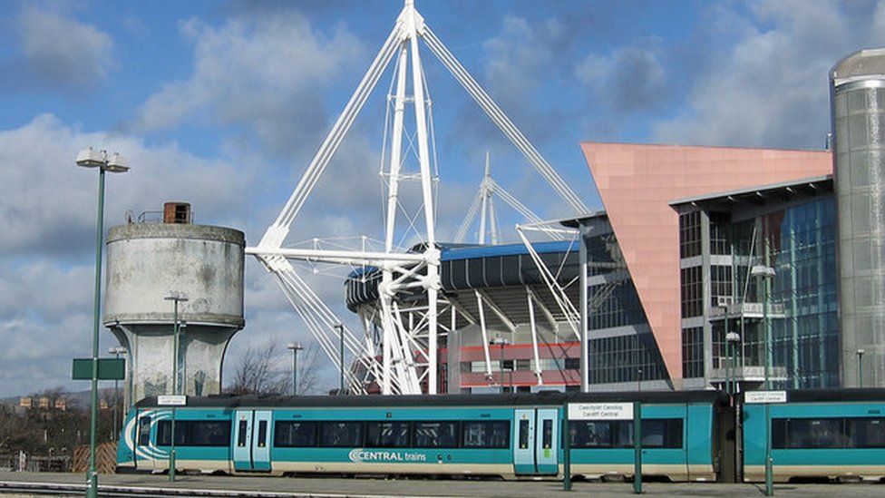 A train at Cardiff station with the Principality Stadium in the background