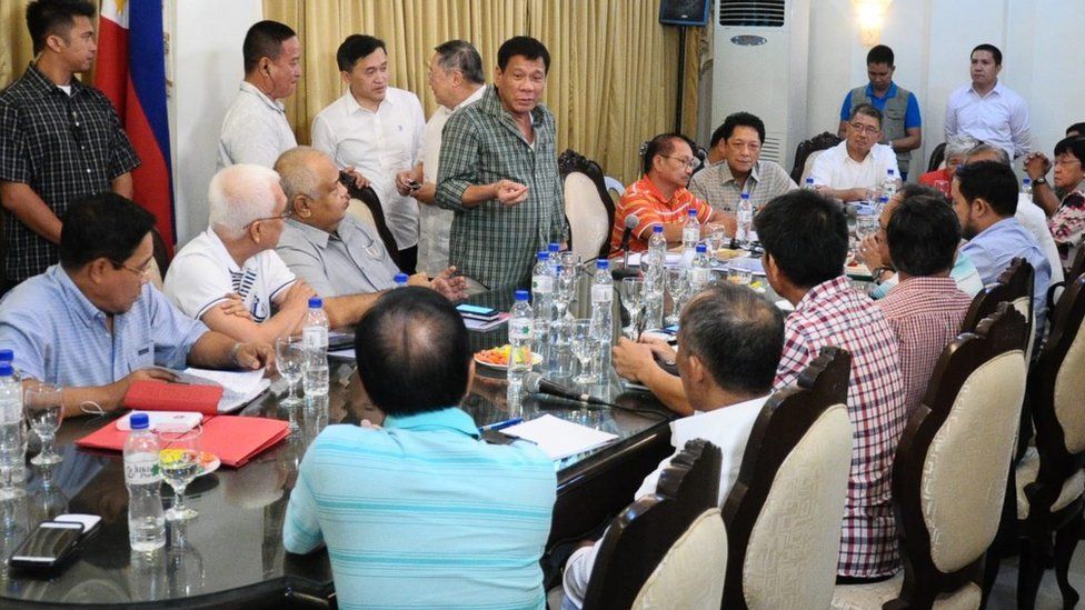 Rodrigo Duterte (centre) speaking to his cabinet - all men, in the picture - around a table in a room in Davao, 31 May 2016.