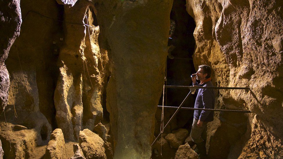 Antonio Rosas beside the Neanderthal child's skeleton.