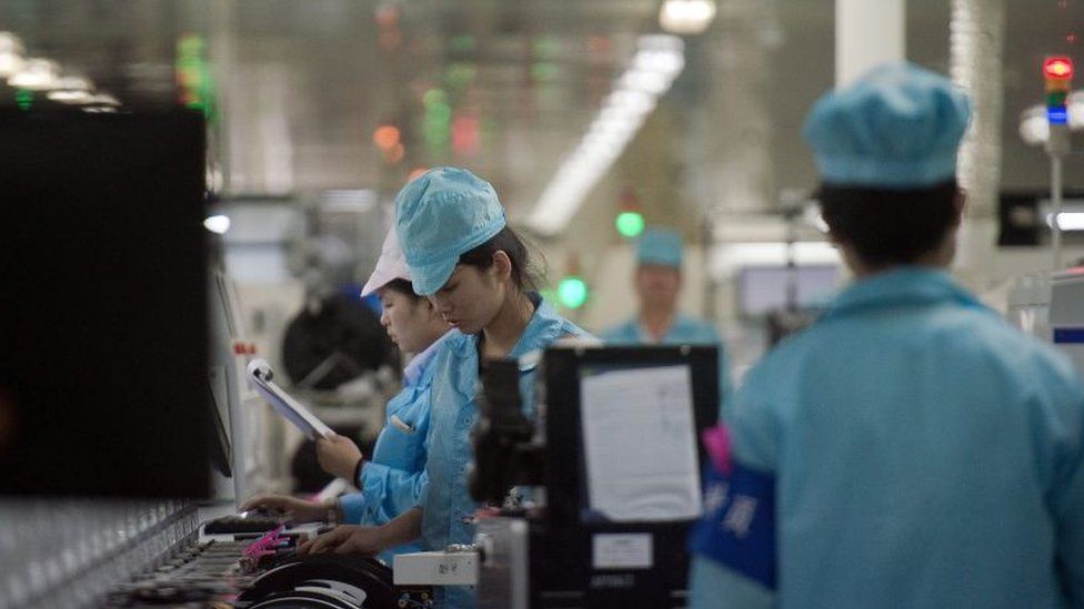 Workers build smartphone chip component circuits at the Oppo factory in Dongguan