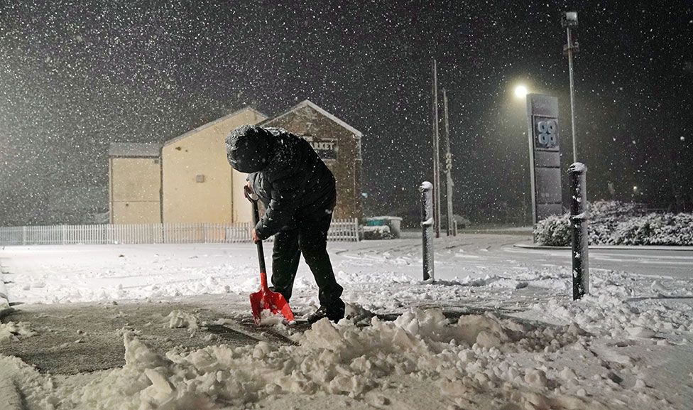 Человек убирает снег в Tow Law, графство Дарем, 18 февраля 2022 г.