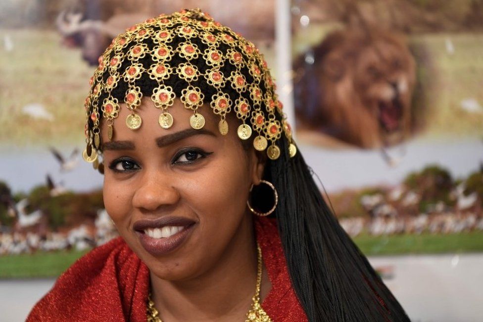 A woman wearing a traditional outfit poses at the Sudanese stand during the International Tourism Fair (FITUR) in Madrid on January 17, 2018