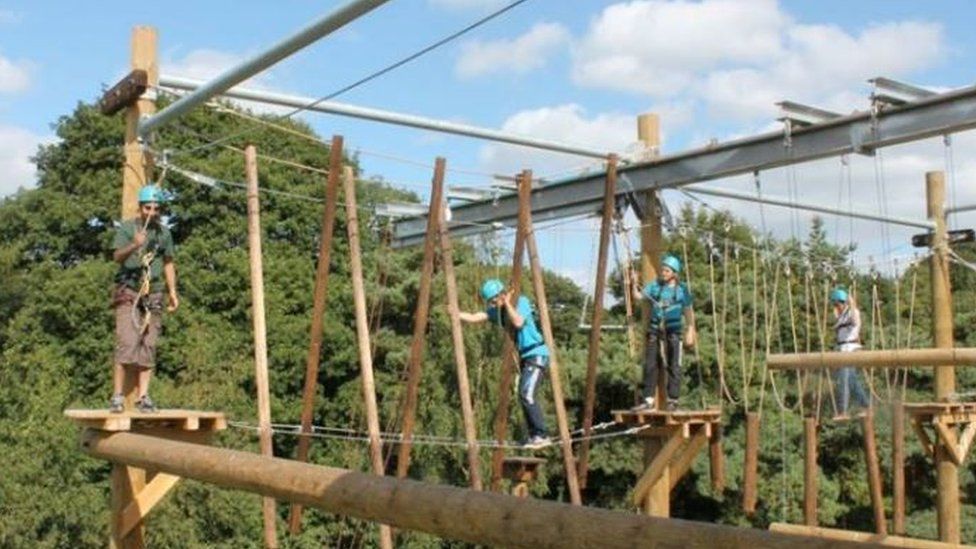 The children try their hand at a high-wire rope course