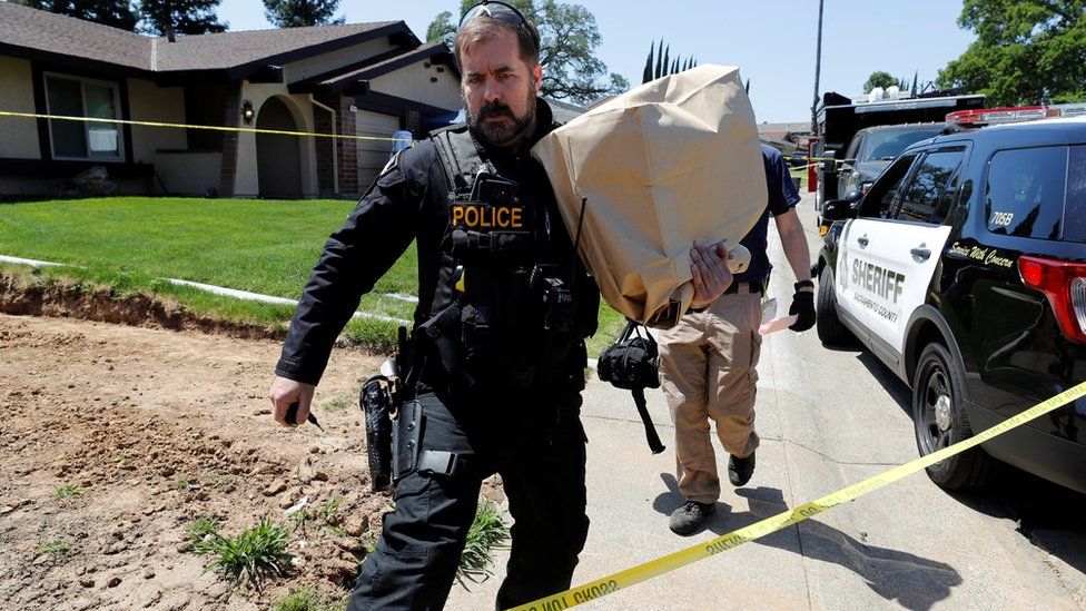 A police officer removes evidence from the home of Joseph Deangelo in Citrus Heights, California, April 26, 2018