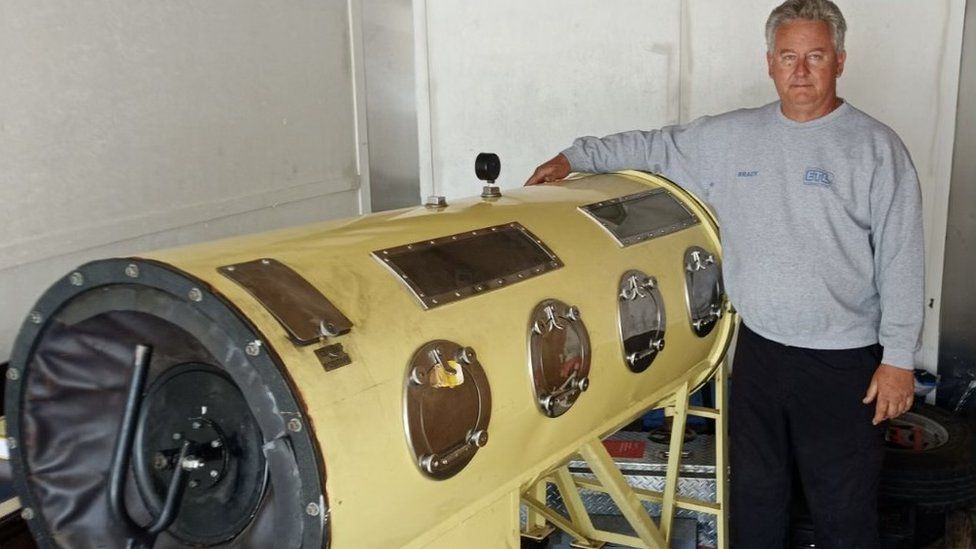 Brady Richards standing next to an iron lung machine
