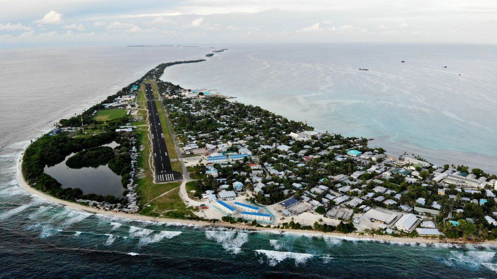An aerial view of downtown and the airport runway, between the Pacific Ocean (L) and lagoon (R), on November 28, 2019 in Funafuti, Tuvalu. The low-lying South Pacific island nation of about 11,000 people has been classified as ‘extremely vulnerable’ to climate change by the United Nations Development Programme.