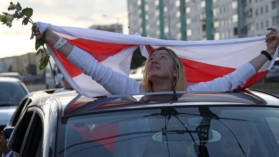 A car passenger displays a Belarusian flag